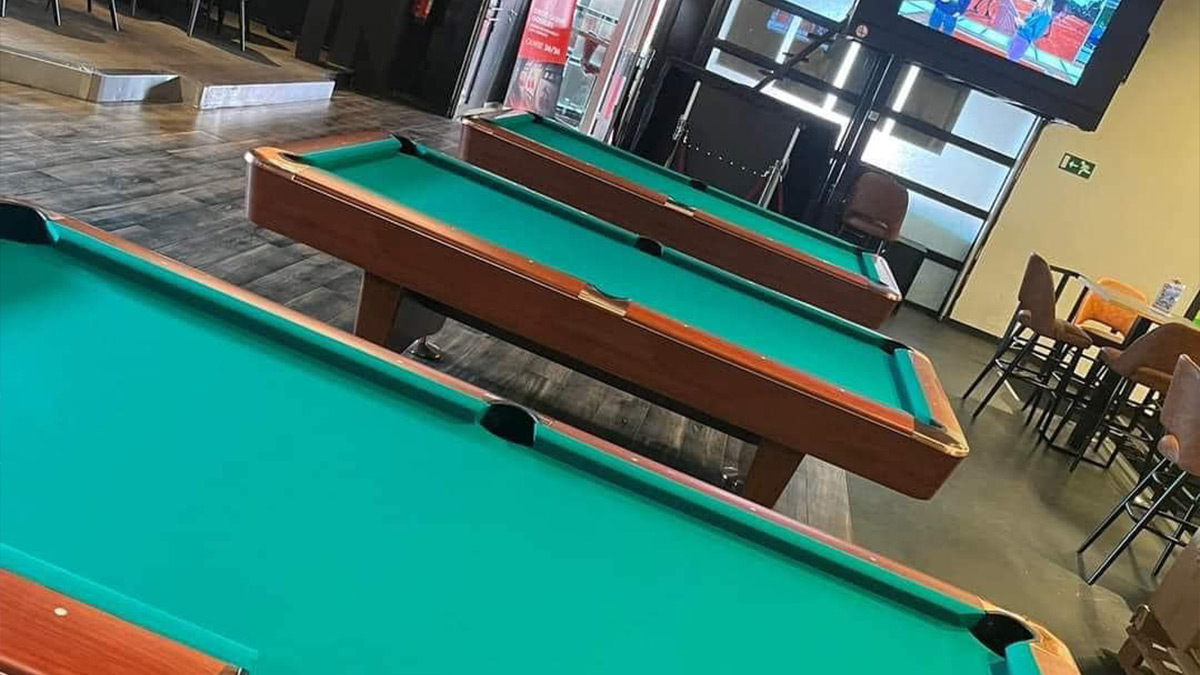 Plusieurs tables de billard dont le tapis est vert foncé